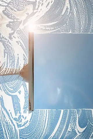 Ein Fenster das gerade durch eine Fensterreinigung in Freiburg gereinigt wird.